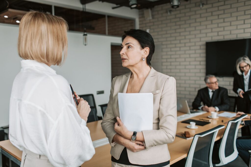 Two colleagues talking during a school leadership meeting