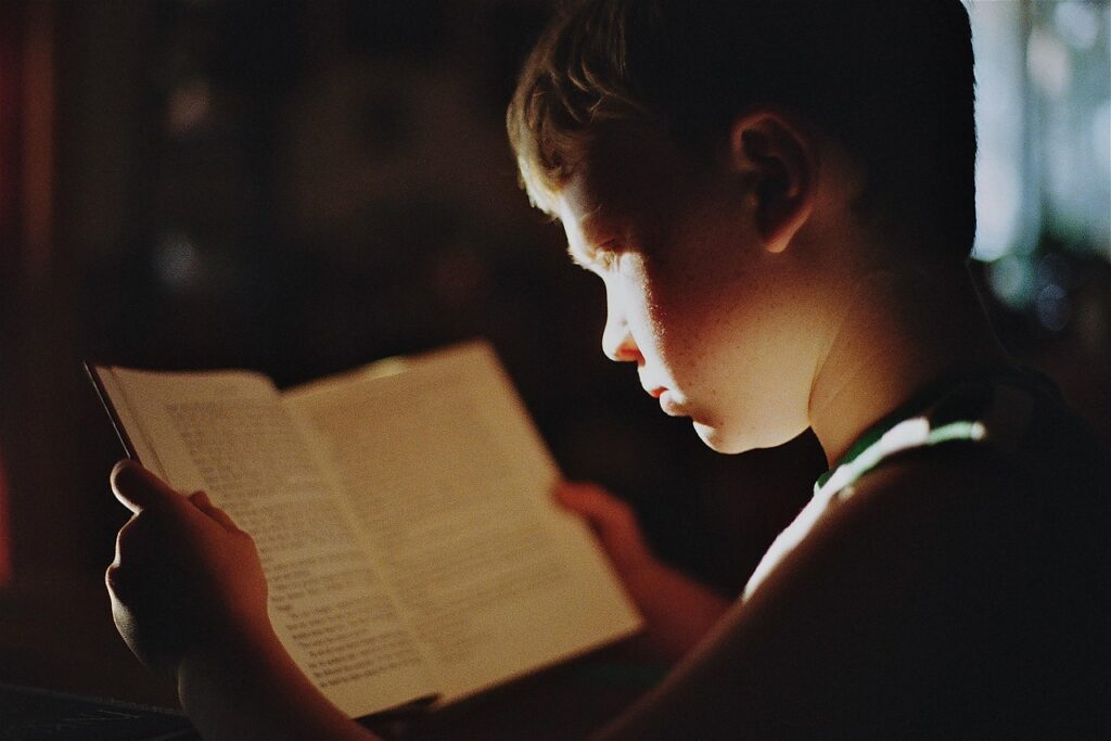 A boy absorbed in reading a book